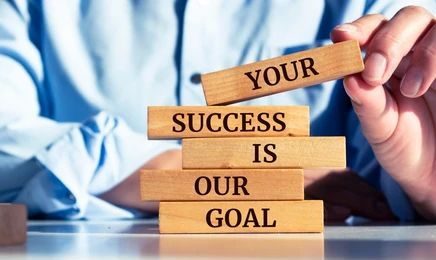 Wooden blocks stacked to read: Your success is our goal